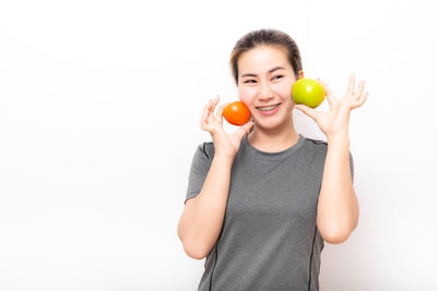 Full length of man holding apple against white background