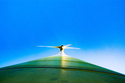 Low angle view of airplane flying against clear blue sky