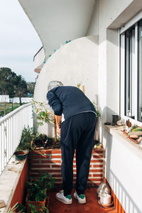 Rear view of man standing by railing