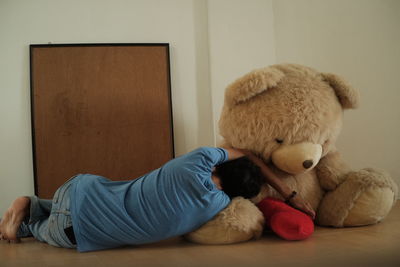 Boy sleeping with toy on bed at home