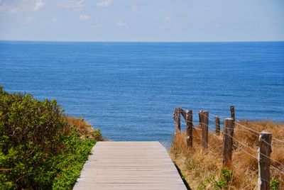 Footpath by sea against sky