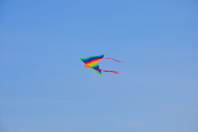 Low angle view of kite flying against clear blue sky