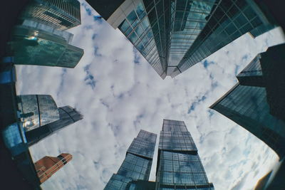 Low angle view of modern building against cloudy sky