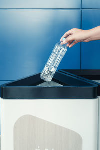 Low angle view of person hand against white wall