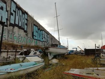 View of abandoned boats moored at shore against sky