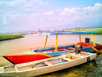 Boats moored in sea against sky