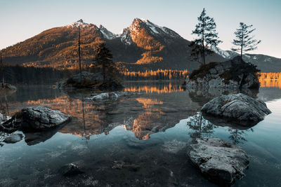 Reflection of rocks in lake against sky