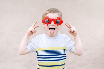 Portrait of cute boy gesturing while wearing sunglasses