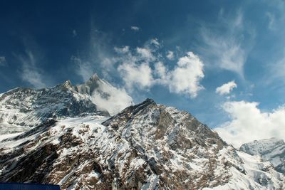 View of snowcapped mountain range against cloudy sky