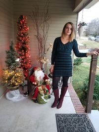 Woman standing by christmas tree