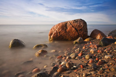 Rocks at beach against sky