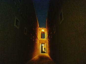 Narrow street amidst buildings at night