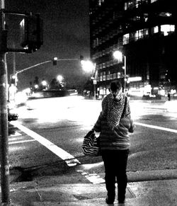 Woman standing on city street at night