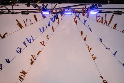 Low angle view of illuminated flags hanging against sky