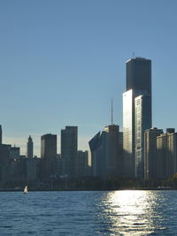 City by river against clear sky