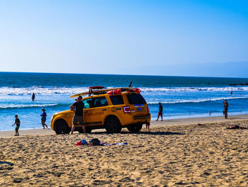 People on beach against clear sky