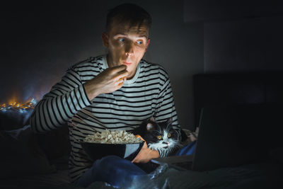 Man watching movie with cat at home