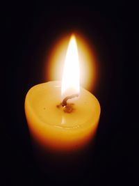 Close-up of lit candle in dark room