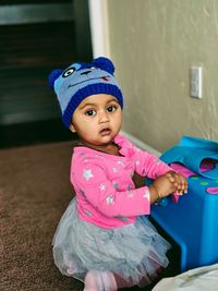 Portrait of baby girl kneeling at home