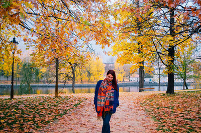 Woman standing by plants during autumn