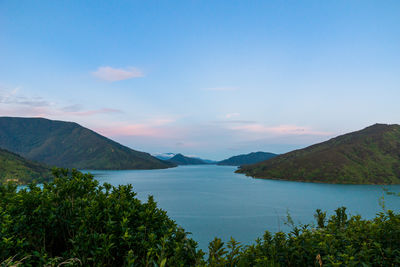 Scenic view of lake by mountains against sky