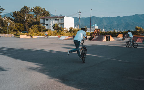 Rear view of man riding bicycle on street