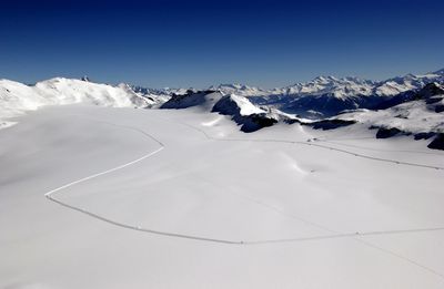 Scenic view of snowcapped mountains against clear blue sky