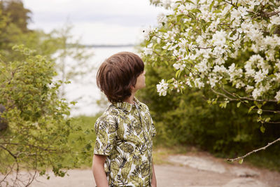 Boy looking at blossoming tree