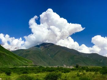 Scenic view of land and mountains against sky
