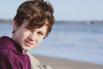 Portrait of boy at beach against sky
