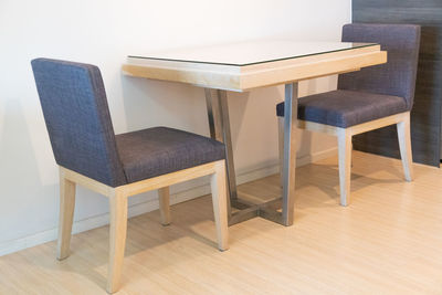 Empty chairs and table against wall at home