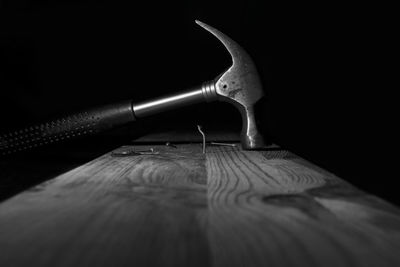 Close-up of pen on table against black background