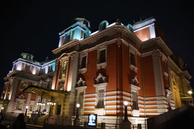 Low angle view of illuminated buildings against sky at night