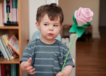 Curious little boy playing with a paper rose