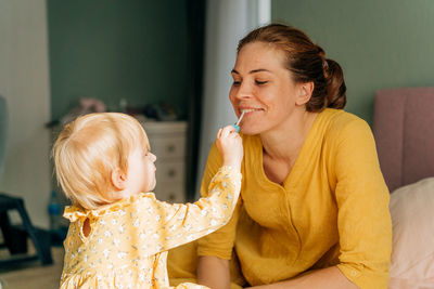 Side view of mother and daughter at home