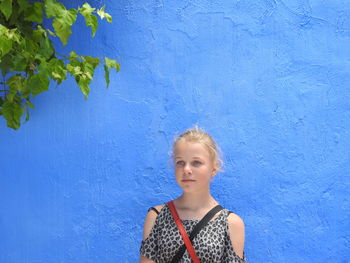 Girl standing against blue wall