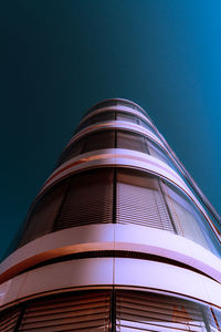 Low angle view of skyscraper against clear sky at night