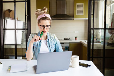 Businesswoman looking at laptop while sitting at home
