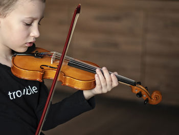 Boy playing violin at home