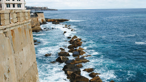 Waves of ocean crashing in rocks in syracusa city in sicily