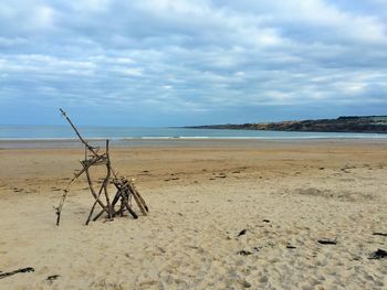 Scenic view of beach against cloudy sky