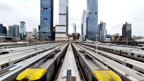 Trains lined up in west side yard, nyc in january 2020 with cityscape in background.