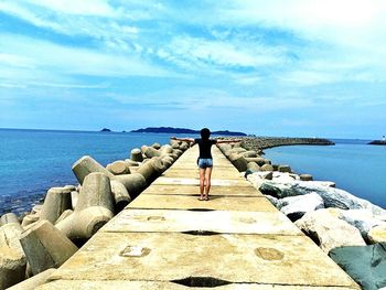 Rear view of man standing on pier