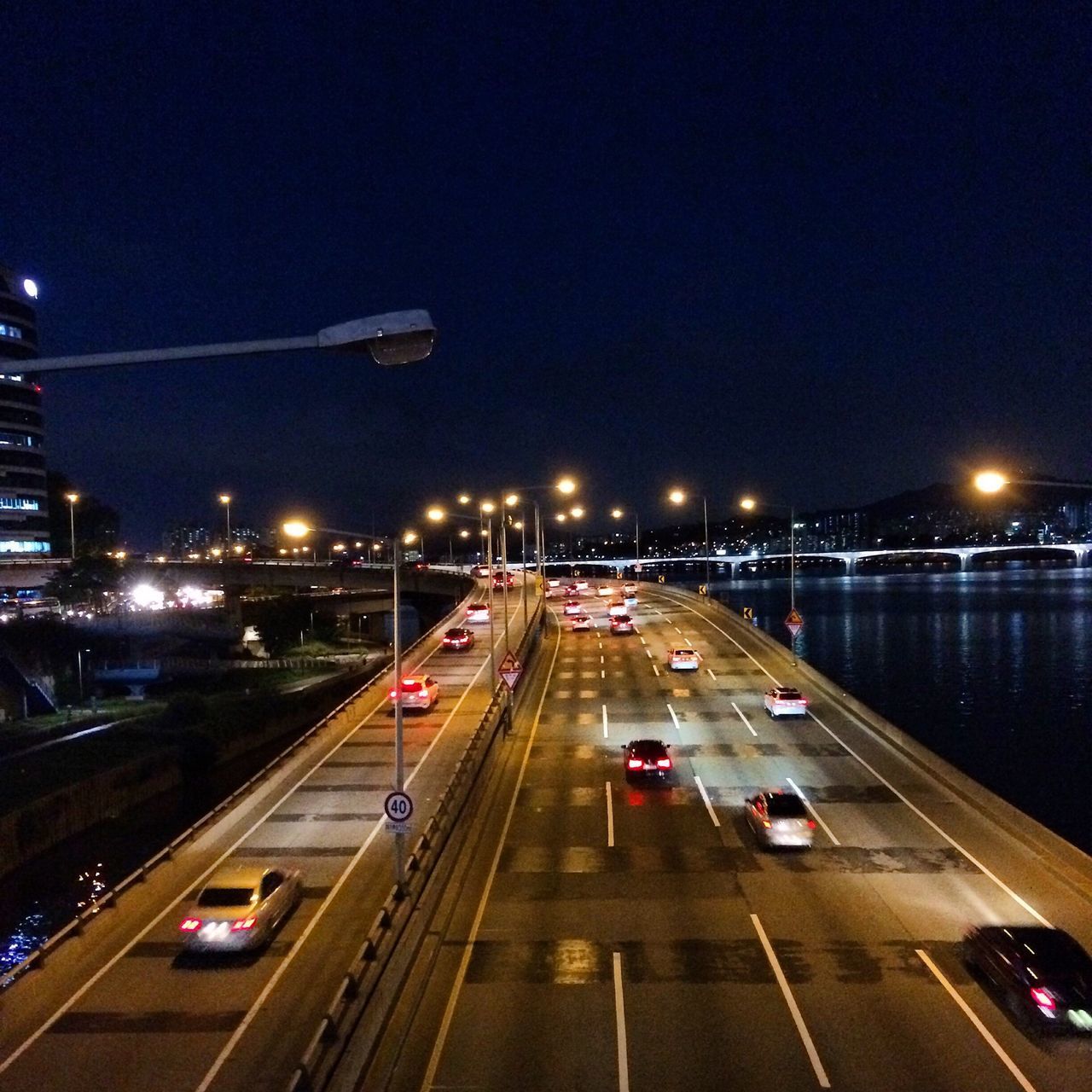 transportation, illuminated, mode of transport, night, on the move, car, city, road, land vehicle, traffic, high angle view, street light, motion, travel, speed, the way forward, highway, road marking, clear sky, moving