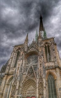 Low angle view of clock tower against cloudy sky