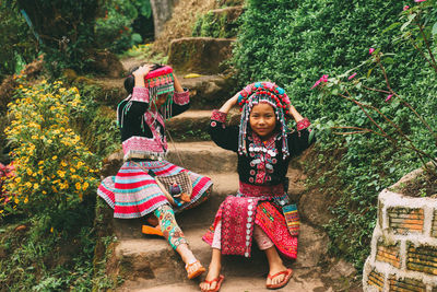 Full length of girl sitting on plants