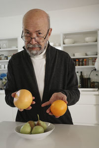 Portrait of senior man holding fruit
