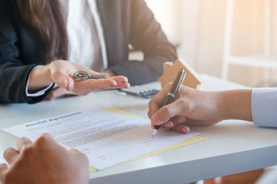 Midsection of woman holding hands on table