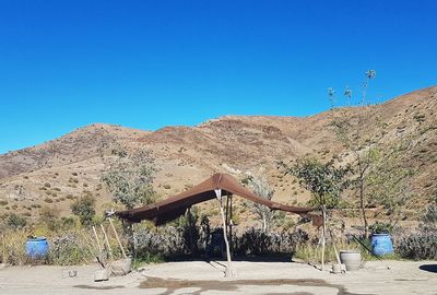 Scenic view of desert against clear blue sky