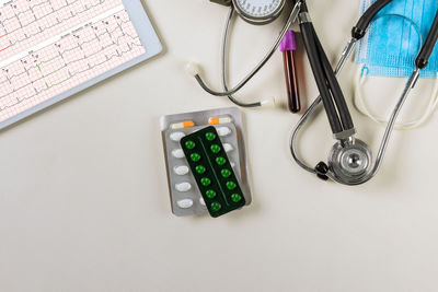 Directly above shot of stethoscope with calculator on table